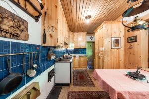 雷西亚Chalet am Reschensee的厨房配有木制橱柜和一张带粉红色桌布的桌子。