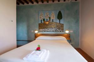 斯坎萨诺Sasseta Alta的卧室配有白色的床和墙上的绘画作品