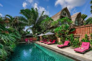 Bangli德科伦普巴厘生态旅游度假村的一座房子旁的游泳池,配有粉红色的躺椅