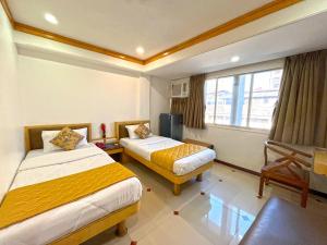 孟买帕克莱恩酒店的酒店客房设有两张床和窗户。