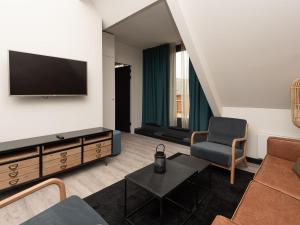 雷讷瑟Luxury apartment in Renesse with infrared sauna的客厅配有电视、沙发和椅子