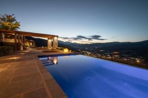 卡拉维塔Chalet Azanias的游泳池,晚上可欣赏到城市景观