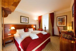 巴德加斯坦萨尔茨堡霍夫酒店的酒店客房设有一张大床和一张书桌。