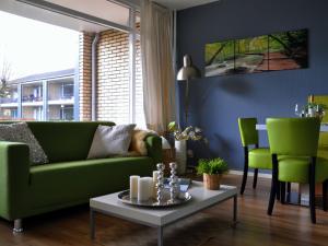 诺德韦克Modern Apartment in Noordwijk near the Sea的客厅配有绿色沙发和桌子