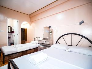 长滩岛Gracias Inn的配有白色床单的客房内的两张床