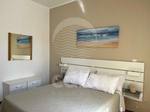托雷拉皮罗Bella Vita - Piano Terra的卧室配有一张床,墙上挂有绘画作品