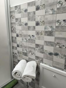 Casa Rosa的一间带2条毛巾和瓷砖墙的浴室