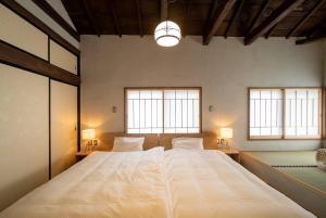 甲府Ebisuya / Vacation STAY 5851的一张大床,位于带两个窗户的房间