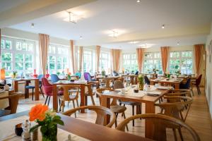 斯匹科罗格科斯特海尔伯格酒店的餐厅设有木桌、椅子和窗户。