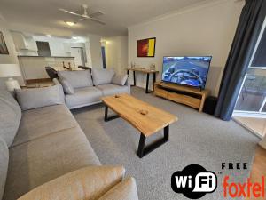 WoorimFairways Golf & Beach Retreat Bribie Island的带沙发和平面电视的客厅