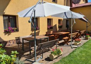 克拉利基Rezidence Lipka的一个带遮阳伞、桌子和长椅的庭院