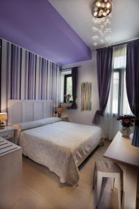 威尼斯丽都亚特兰大奥古斯塔斯酒店的一间卧室设有一张大床和紫色天花板。