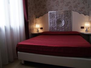 威尼斯丽都亚特兰大奥古斯塔斯酒店的一间卧室配有一张红色床罩的床