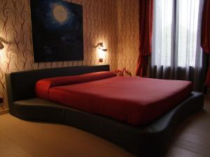 威尼斯丽都亚特兰大奥古斯塔斯酒店的一间卧室配有一张床铺,床上铺有红色毯子