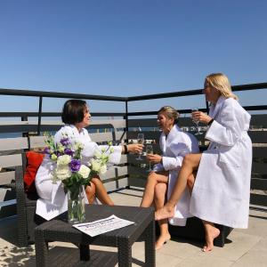 敖德萨Continental Hotel的三个女人坐在阳台上喝葡萄酒