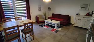 瓦尔内明德Sandsturm的客厅配有红色的沙发和桌子