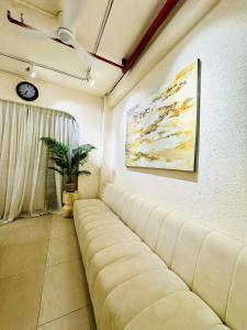 胡志明市托伊旅游中心旅舍的带沙发和绘画的客厅