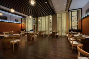 多哈Swiss-Belinn Doha的餐厅设有桌椅和窗户。
