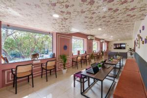 斋浦尔The Hosteller Jaipur, MI Road的餐厅设有桌椅和鲜花天花板