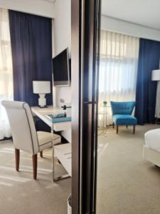 马德里纽沃波斯顿酒店的酒店客房配有书桌、沙发和桌子。