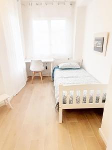 雷乌斯Tarragonaapartments Prim 350的白色的卧室设有床和窗户