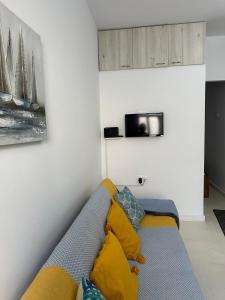 圣加利尼Maria Galini Home的客厅配有蓝色沙发及黄色枕头