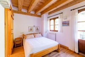 FagoCasa Tadeguaz的一间带一张床的卧室,位于带木制天花板的房间内