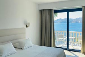 阿齐亚佩拉加半岛Spa度假村的一间卧室配有一张床,享有海景