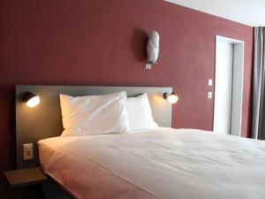 Siebnen斯托伯格酒店公寓的卧室配有白色的床铺和红色的墙壁