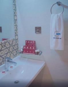 卡拉奇Pearl Inn Hotel的浴室配有白色水槽和毛巾