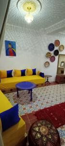 丹吉尔Dar Rif Kebdani的客厅配有黄色的沙发和桌子