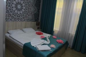 AksayAltyn Shatyr Hotel and Restaurant的一间卧室配有带毛巾和鲜花的床