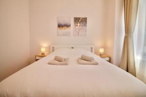 布鲁塞尔Heart of Grand Place - Stunning 3BR Triplex的卧室配有一张带两个枕头的大白色床