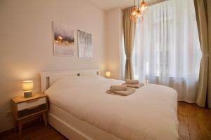布鲁塞尔Heart of Grand Place - Stunning 3BR Triplex的卧室配有白色的床和2条毛巾