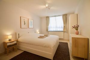 布鲁塞尔Heart of Grand Place - Stunning 3BR Triplex的卧室配有白色的床和窗户。