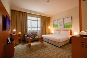 多哈Swiss-Belinn Doha的配有一张床和一把椅子的酒店客房