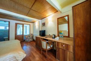 列城Hotel Shambhala Resort的一间卧室配有一张桌子、一张床和一面镜子