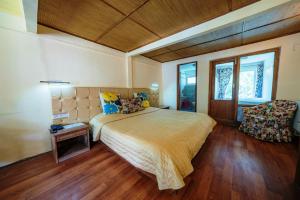 列城Hotel Shambhala Resort的一间卧室配有一张大床和一把椅子
