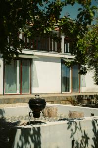 奥利维拉多霍斯比托Pura - Home in Nature的坐在大楼前壁炉旁的烤架