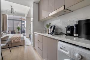 迪拜GuestReady - Urban Retreat in Downtown的一间厨房,配有白色的橱柜和一张位于客房内的床