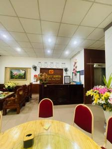 Dong QuanNew Sky Hotel的一间设有桌椅和鲜花的等候室