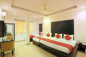 新德里Airport Hotel Chanakya的一间卧室配有一张带红色枕头的大床