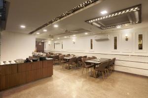 新德里Airport Hotel Chanakya的一间在房间内配有桌椅的餐厅