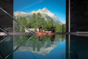 席尔瓦普拉纳尼拉阿尔皮纳酒店的坐在山中游泳池中的男女