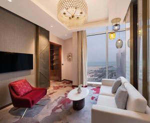 多哈Velero Hotel Doha Lusail的客厅配有白色沙发和红色椅子