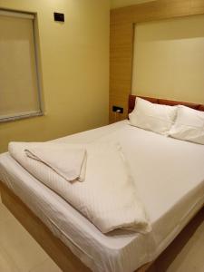 GauripurHOTEL SKYKING的一张白色大床,配有白色床单和枕头