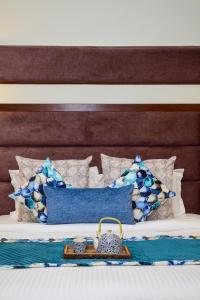卢迪亚纳Sonam Plaza的一张带蓝色和白色枕头的床,上面装有钱包
