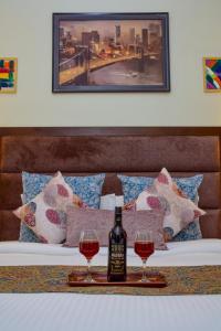 卢迪亚纳Sonam Plaza的床上有一瓶葡萄酒和两杯酒