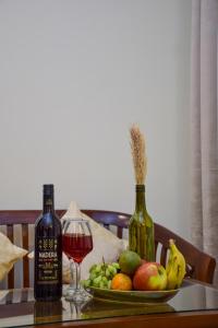 卢迪亚纳Sonam Plaza的一张桌子,上面放着一盘水果和一杯葡萄酒