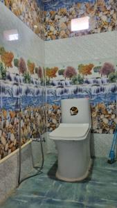 TānsenElephant Top Holiday Nepal, Homestay, Tansen的浴室设有卫生间,配有木壁画